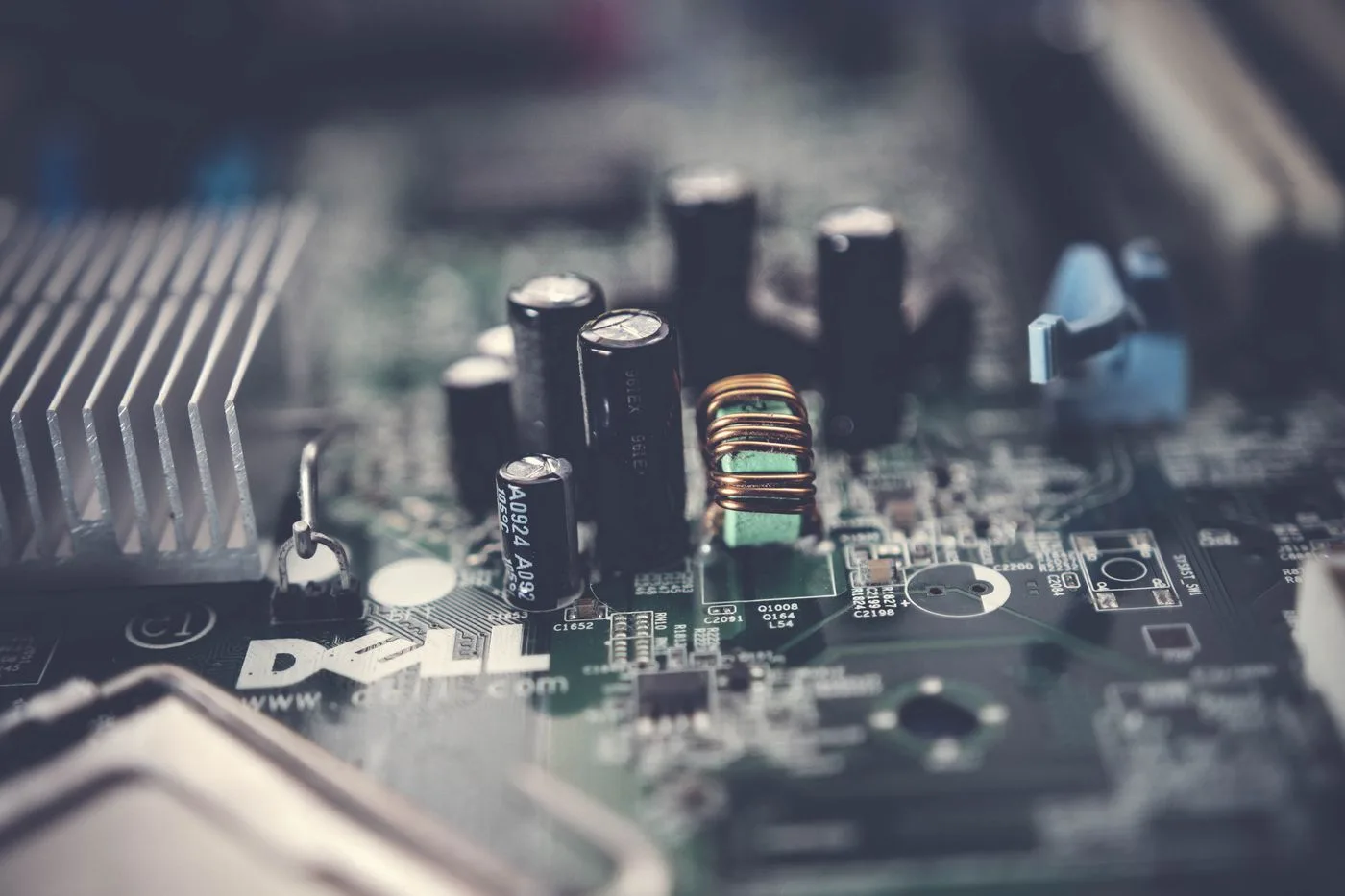 Close-up of a computer motherboard with capacitors, circuits, and a heatsink